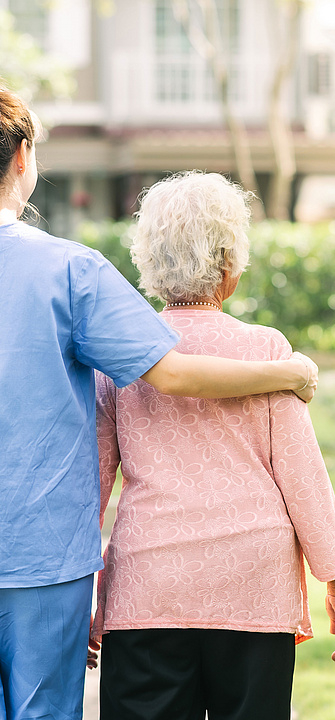 Pflege Eine Pflegerin begleitet eine ältere Frau