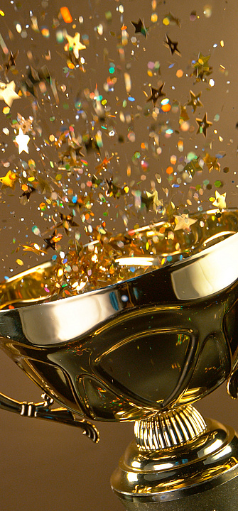 Preisverleihung Ein Pokal aus dem Confetti sprüht auf goldenem Hintergrund