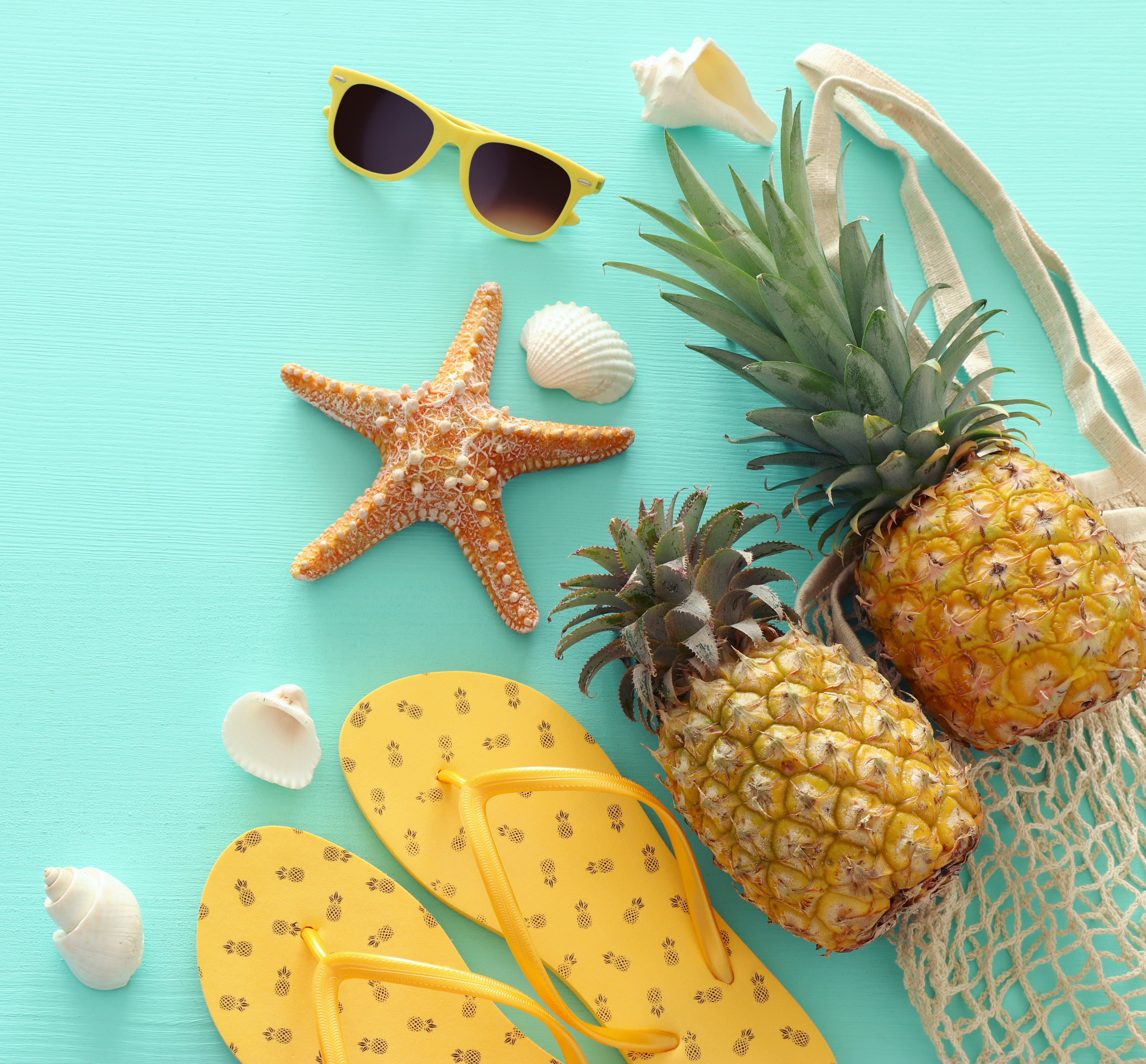 Ananas und Strand-Accessoires auf pastellfarbenem Mint Ananas und Strand-Accessoires auf pastellfarbenem Mint